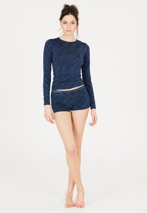 Mørkeblå langærmet træningstrøje med et struktureret mønster, parret med matchende shorts. Stoffet virker let og fleksibelt.