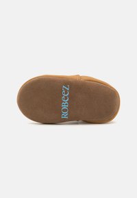 Suola di scarpa in suede marrone, forma arrotondata, con il marchio blu "ROBEEZ", texture liscia e leggera curvatura per flessibilità.