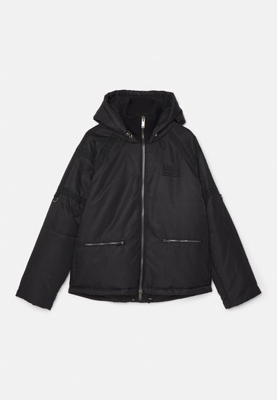 Juodas pūkinis jakas su kapišonu, turintis užtrauktukus kišenėse, raukšlėtą vidinį apykaklę ir tekstūruotus šoninius panelius. Priekinis užtrauktukas ir laisvas siluetas.