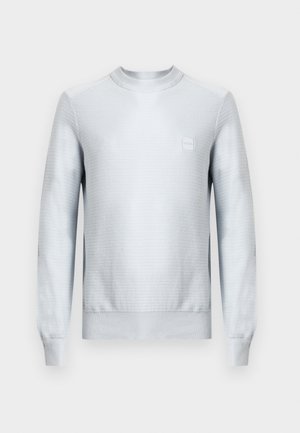 Helehall teksuurse kangaga dressipluus, pikkade varrukatega, ümara kaelusega ja ruudukujulise logomärgiga rinnal. Lame ääreliist.