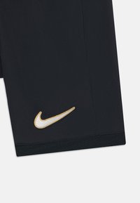 Mustad sportlikud lühikesed püksid elastse vöökohaga, millel vasakul küljel on kuldse tikkimisega Nike logo ja ääres võrktekstuur.