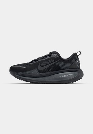 Melns Nike skriešanas apavas ar elpojošu acs augšdaļu, teksturētām akcentiem, mīkstu apmali un izliekta ZoomX zole, kas nodrošina uzlabotu amortizāciju.