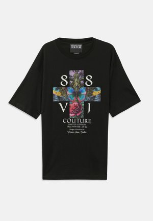 Black oversized t-shirt featuring a colorful graphic design with a butterfly, roses, and text, made of soft cotton fabric.