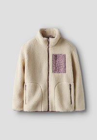 Beige Sherpa-Fleecejacke mit durchgehendem Frontreißverschluss, zwei seitlichen Reißverschlusstaschen und einer violetten Brusttasche mit Leopardenmuster.