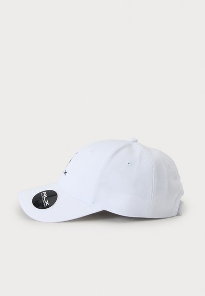 Casquette de baseball blanche avec une visière incurvée et des trous de ventilation, vue de profil sur un fond clair uni.