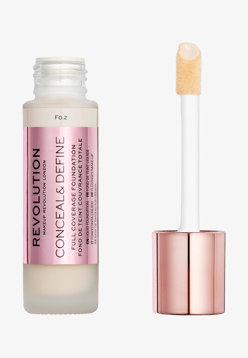 Revolution Conceal & Define foundation, glass bottle with pink and white accents, features a fluffy applicator and creamy beige product tip.
