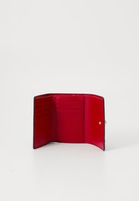 Portafoglio in pelle nera con un interno rosso brillante, dotato di numerosi scomparti per carte e chiusura a scatto. Texture liscia, design minimalista.