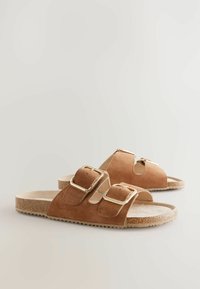 Sandale din suede maro cu două curele reglabile cu catarame, un suport pentru picior căptușit și o talpă texturată din plută.