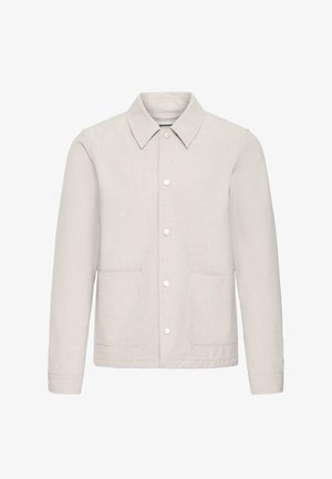 Chaqueta casual beige con cuello puntiagudo, cierre de botones, mangas largas y dos bolsillos frontales con parche, mostrada sobre un fondo blanco.