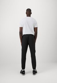 Puma FLEX CARGO PANT - Pantalon de survêtement - black