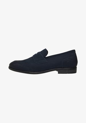 Navyblaue Wildleder-Slipper mit einer gestickten Naht, abgerundetem Zeh und flacher schwarzer Gummisohle. Mit einem dekorativen Klapp vorne.