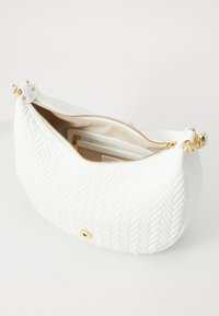 White faux leather handbag with a braided texture, gold hardware, and a zip closure. Interior includes a zip pocket and additional space.