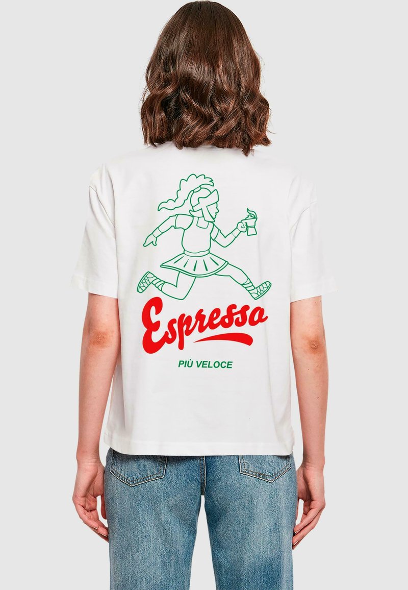 Camiseta blanca con una ilustración en línea verde de una figura corriendo con una bebida, con "Espresso" en rojo y "PIÙ VELOCE" en texto verde debajo.