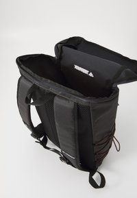 Black backpack with a zip closure, mesh fabric sides, adjustable straps, and a spacious interior. Features a logo inside the top.