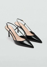 Zwarte pumps van lakleer met slingback, spitse neuzen en slanke hakken. Voorzien van dunne bandjes en een minimalistisch ontwerp.