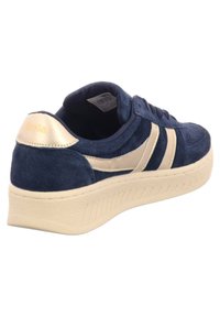 Sneaker in suede blu navy con accenti crema, caratterizzato da una suola spessa e testurizzata, punta arrotondata e logo Gola sul tallone.