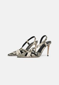 Scarpe con tacco a spillo slingback in motivo rettile bianco e nero, con punta affilata, cinturini incrociati e tacco a stiletto elegante.