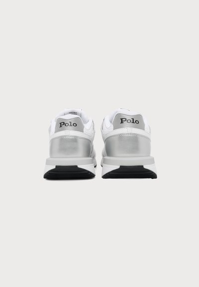 Ζευγάρι λευκά και ασημένια Sneakers Polo, εμφανιζόμενα από πίσω σε απλό φωτεινό φόντο.