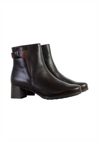 Bottes chevilles en cuir marron avec un bout carré et un talon empilé. Dotées d'une sangle d'accent texturée et d'une surface lisse pour un design élégant.