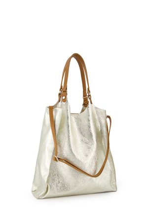 Velká stříbrná taška přes rameno s texturovaným povrchem, vybavená dvěma hnědými koženými držadly a nastavitelným ramenním popruhem.