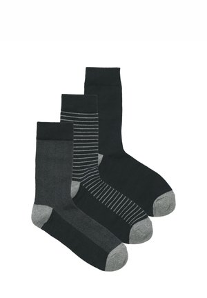 Drie paar sokken in donkere kleuren: één effen donkergrijs, één met dunne grijze strepen, en één met een visgraatmotief en grijze accenten.