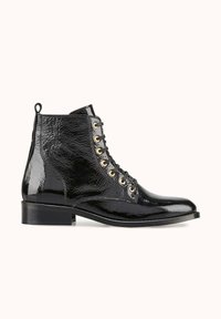 Bottine en cuir verni noir à finition brillante, bout rond, œillets dorés et lacets noirs, dotée d'un petit talon bloc et d'une languette de tirage.