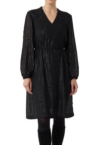 Czarna sukienka z dekoltem w serek, długimi rękawami i błyszczącą, teksturowaną powierzchnią z pionowymi paskami. Posiada dopasowaną talię oraz rozkloszowaną spódnicę.