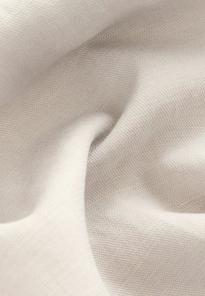 Lys beige stof med en glat tekstur, der har et subtilt vævet mønster. Materialet virker blødt og falder let.