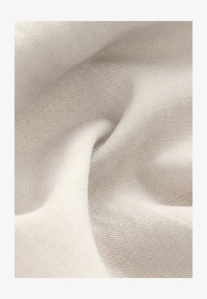 Heledbeez värvusega kangas, millel on sile tekstuur ja peene kudumise muster. Materjal paistab pehme ja langeb õrnalt.