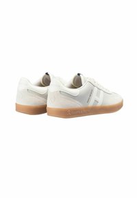 Zapatillas blancas con detalles de ante, suelas de goma y diseño minimalista. Presentan un logo en el lateral y marca en el talón.