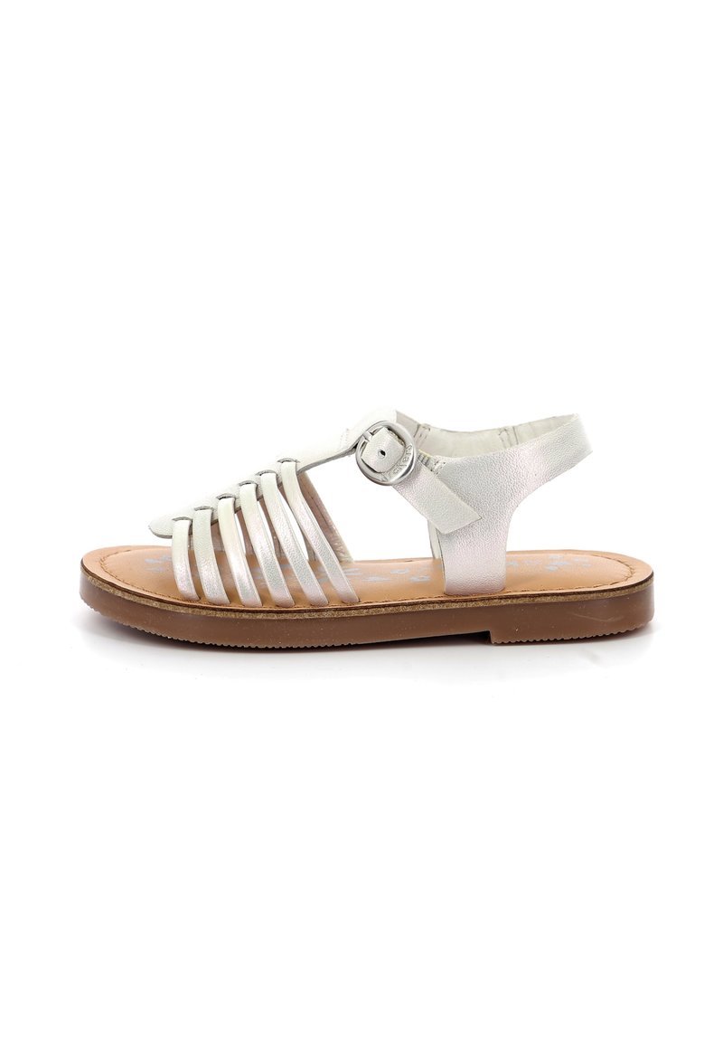 Sandalias de cuero blancas con tiras, que cuentan con múltiples tiras a través del pie, una correa para el tobillo con hebilla, y una suela marrón con un patrón texturizado.