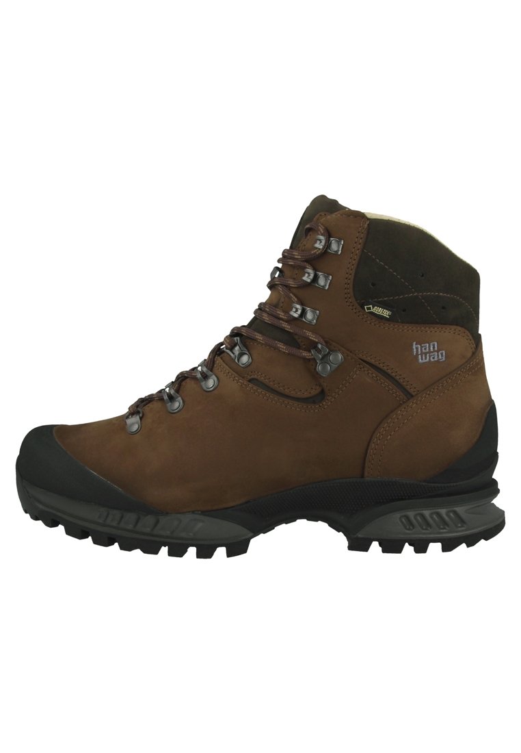 Bottes de randonnée en cuir marron avec une semelle en caoutchouc noir solide, des œillets en métal pour les lacets et une cheville rembourrée pour le soutien.