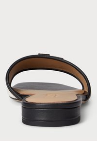 Musta nahkainen liukuva sandaali, jossa on kaareva hihnadesign. Sujuva pohja ja teksturoitu pohja. Korostettu kontrastivalkoisella raidalla sivussa.