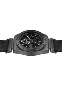 Schwarze Skelettuhr mit automatischem Mechanismus, strukturiertem Lederarmband, konturiertem Gehäuse und auffälligen Markierungen auf einem dunklen Zifferblatt.