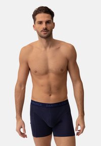 Bóxers azul marino con una textura suave, que cuentan con una amplia banda elástica grabada con "DANISH ENDURANCE". Diseñados para la comodidad.