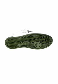Suola di sneaker bianca con grip testurizzato verde, motivo circolare vicino alla palla del piede e logo a stella visibile sul lato.