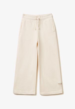 Roomy sweatpants in crèmekleur met elastische tailleband, trekkoord, zijzakken en een klein logoplaatje bij de zoom, afgebeeld op een effen achtergrond.