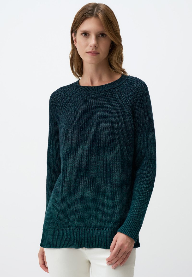 Donkerblauwe gebreide trui met een ronde hals, lange mouwen en ribbels aan de onderkant. De textuur is grof en gezellig, perfect voor casual kleding.