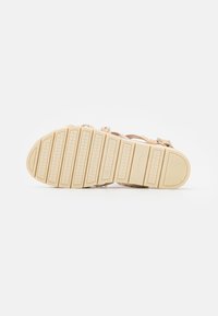 Bruna sandaler med en strukturerad gummisula, utrustade med justerbara remmar och metalliska detaljer, designade för komfort och grepp.