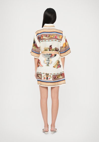 Abito in stile kimono di colore bianco con stampe colorate di frutta e fiori, maniche corte e vita cinchata. Presenta un orlo decorativo.