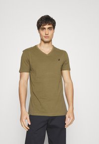 Olive green short-sleeve T-shirt with a V-neck and a small black logo on the chest. Made of soft fabric with a smooth texture.