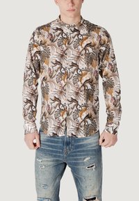 Camicia a maniche lunghe con base bianca caratterizzata da una stampa colorata di una giungla con scimmie e foglie nei toni del marrone e del verde; colletto a bottone.