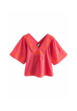 Rosa Bluse mit weiten Ärmeln, verziert mit orangefarbenen, bestickten Blumen- und Ananasmustern, V-Ausschnitt mit drei vorderen Knöpfen.