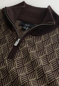 Braun gemusterter Reißverschluss-Pullover mit hohem gerippten Kragen. Verfügt über ein geometrisches Design in Dunkel- und Hellbraun. Silberne Reißverschlussbeschläge.