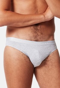Graue Baumwollunterhosen mit einem hellgrauen elastischen Bund, auf dem das Wort "SKINY" eingeprägt ist. Glatte Textur mit passgenauer Form.