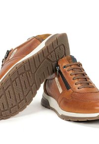 Baskets en cuir brun avec un design texturé, un devant à lacets, une fermeture éclair sur le côté et une semelle en caoutchouc crantée pour une meilleure adhérence.