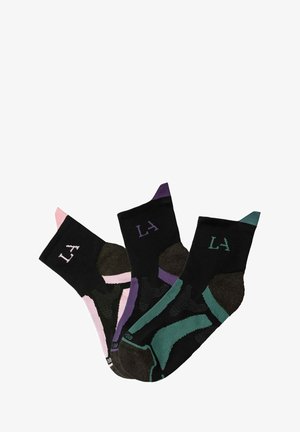 Drei Paare schwarze Socken mit verschiedenen Akzenten: eine mit pink, eine andere mit lila und die letzte mit türkis. Jede hat "LA" aufgedruckt.