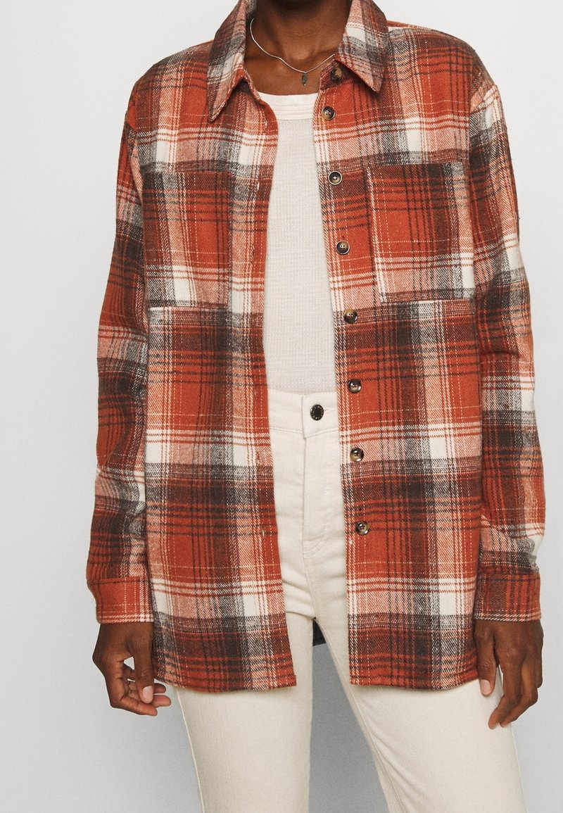 Rood-wit geruit overhemd van flanellen stof, met een knoopsluiting aan de voorkant, lange mouwen en een klassieke kraag met een ontspannen pasvorm.