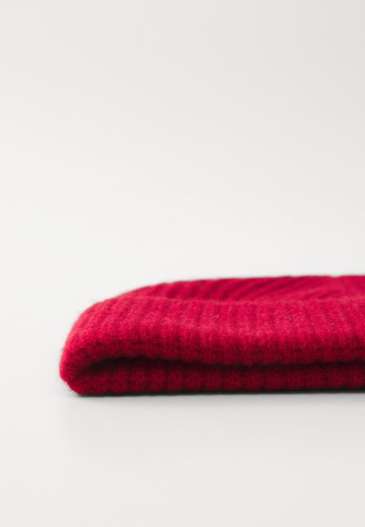 Rød strikket beanie-hat, foldet, med ribbet tekstur. Lavet af blødt materiale, med en tætsiddende design og lys farve.