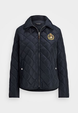 Navy quilted jacket with collar, front zipper, side pockets, and decorative gold emblem on the left chest. Smooth nylon material.